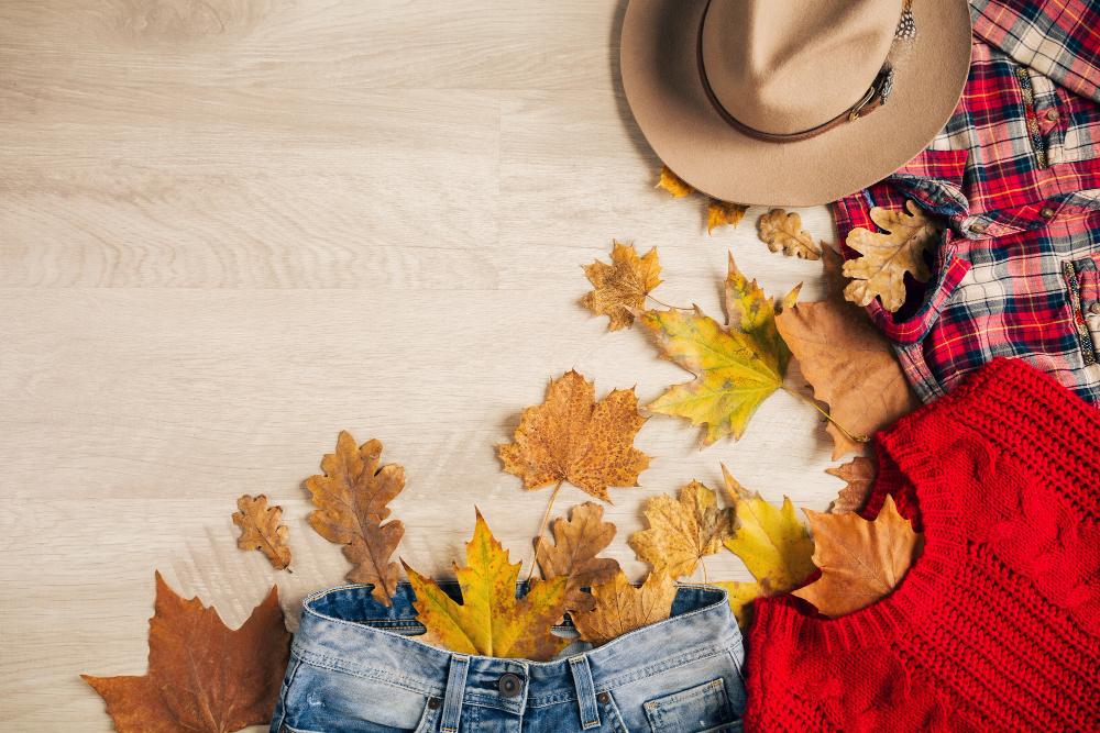 Mise plat du style femme accessoires pull tricot rouge chemise carreaux jeans denim chapeau tendance mode automne vue haut vetements feuilles jaunes